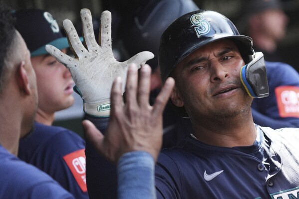 Seattle Mariners' Donovan Solano celebrates with teammates after hitting a two-run home run during the seventh inning of a baseball game against the Chicago Cubs in Chicago, Sunday, June 22, 2025. (AP Photo/Nam Y. Huh)