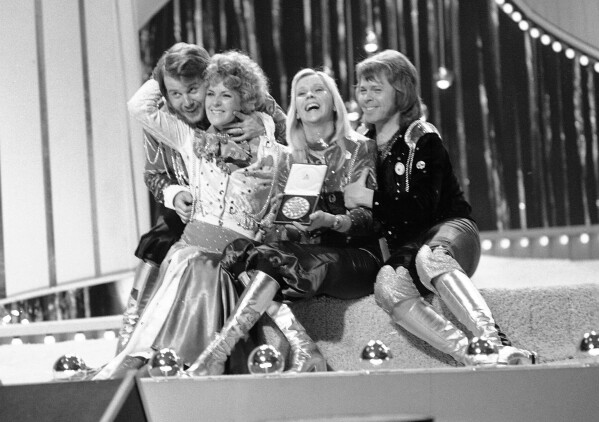 FILE - In this April 6, 1974 file photo, Swedish pop group ABBA celebrate winning the 1974 Eurovision Song Contest on stage at the Brighton Dome in England with their song Waterloo. Fans are celebrating 50 years since ABBA won its first big battle with “Waterloo.” A half century ago on Saturday, April 6, the Swedish quartet triumphed at the 1974 Eurovision Song Contest with the peppy love song. (AP Photo/Robert Dear, File)