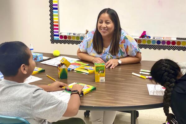 Lety Vargas, a newly hired English Language teacher at Russellville Elementary School, in Russellville, Ala., coaches small groups of students on her first day of school, Aug. 9, 2022. For years, rural Russellville's Central American population has grown, with immigrants moving to town to work at the local chicken processing plant. Now, some Spanish-speaking adults who graduated from that same school system are returning to teach students, hoping to give today's English learners a better experience. (Rebecca Griesbach/AL.com via AP)