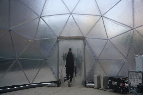 A person exits a pollution pod designed to mimic the air quality in New Delhi at the COP28 U.N. Climate Summit, Dec. 2, 2023, in Dubai, United Arab Emirates. (AP Photo/Joshua A. Bickel)