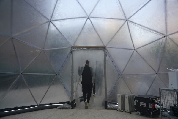 A person exits a pollution pod designed to mimic the air quality in New Delhi at the COP28 U.N. Climate Summit, Dec. 2, 2023, in Dubai, United Arab Emirates. (AP Photo/Joshua A. Bickel)