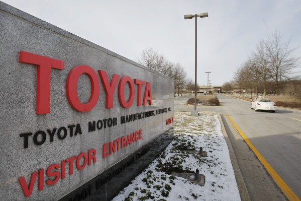 FILE - A car drives past the entrance to the Toyota Motor Manufacturing plant is seen in Georgetown, Ky., Jan. 27, 2010. Toyota says it will invest $1.3 billion at its huge factory complex in Georgetown, in part so it can build an all-new three-row electric SUV to be sold in the U.S. The company says the money will help with future electric vehicle production, including the addition of a line to assemble battery cells into packs for other EVs. But it won’t add any new jobs to the complex, which now employs nearly 9,400 workers. The investment brings to nearly $10 billion the amount of money that Toyota has spent at the plant, the company said in a statement Tuesday, Feb. 6, 2024. (AP Photo/Ed Reinke, file)