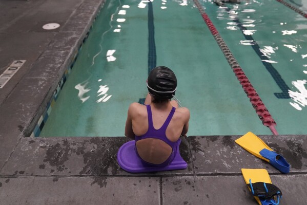 FILE - A 12-year-old transgender swimmer is seen waiting by a pool, Feb. 22, 2021, in Utah. She and her family spoke to APon the condition of anonymity. Transgender teenagers challenging a Utah law banning trans girls from playing on girls' sports teams can keep portions of their mental health records confidential after a state judge ruled Thursday, Dec. 7, 2023, that some details were irrelevant to the case. (APPhoto/Rick Bowmer, File)