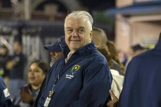 FILE- Nevada Gov. Steve Sisolak stands on the sidelines before a NCAA college football game in Reno, Nev., on Oct. 29, 2021. Sisolak announced, Tuesday, Jan. 18, 2022, that he raised $4.5 million in 2021, that is more than the Republican gubernatorial candidates combined who are seeking to unseat him in the 2022 election. (AP Photo/Tom R. Smedes,File)