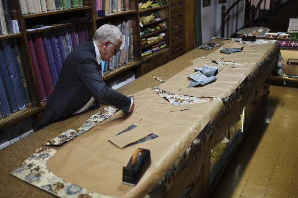 A tailor works at the Gammarelli ecclesiastic clothes tailor shop in Rome, Wednesday, April 30, 2025. (AP Photo/Francisco Seco)