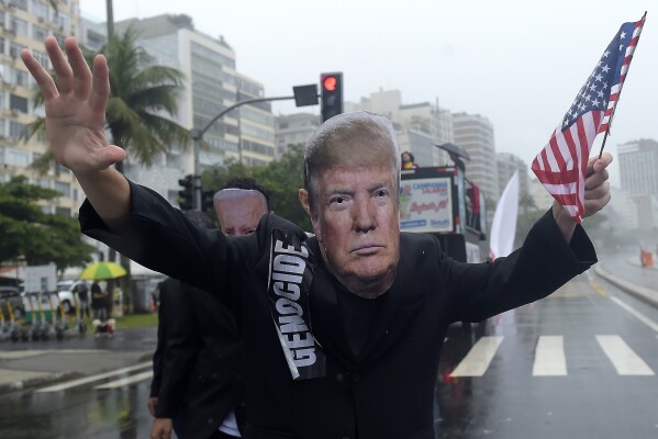 A demonstrator wearing a mask depicting President-elect Donald Trump takes part in a protest organized by social movements aimed at drawing the attention of leaders attending the upcoming G20 Summit, in Rio de Janeiro, Saturday, Nov. 16, 2024. (AP Photo/Dhavid Normando)