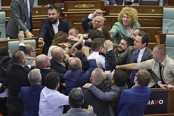 Lawmakers push each other as a brawl breaks out in Kosovo's parliament in Pristina, Kosovo, Thursday, July 13, 2023. A brawl erupted in the Kosovo parliament on Thursday after an opposition lawmaker threw water on Prime Minister Albin Kurti while he was speaking about government measures to defuse tensions with ethnic Serbs in the country's north. Kosovo opposition parties have criticized Kurti's policies in the north that have strained relations with key Western allies. (AP Photo/Ridvan Slivova)
