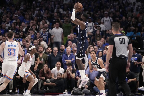 Dallas Mavericks forward Tim Hardaway Jr. (10) shoots and sinks a 3-point basket over Oklahoma City Thunder's Gordon Hayward (33) and Shai Gilgeous-Alexander, left rear, as referee Gediminas Petraitis (50) looks on during the second half in Game 3 of an NBA basketball second-round playoff series, Saturday, May 11, 2024, in Dallas. (AP Photo/Tony Gutierrez)