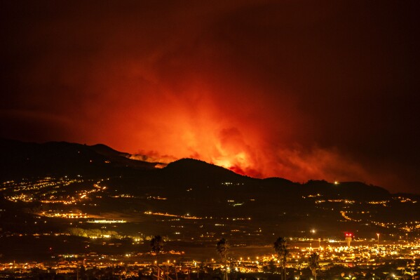 Flares are seen on the horizon as the fire advances through the forest toward the town of La Laguna and Los Rodeos airport in Tenerife, Canary Islands, Spain on Saturday, Aug. 19, 2023. Firefighters have battled through the night to try to bring under control the worst wildfire in decades on the Spanish Canary Island of Tenerife, a major tourist destination. The fire in the north of the island started Tuesday night and has forced the evacuation or confinement of nearly 8,000 people. Regional officials say Friday's efforts will be crucial in containing the fire. (AP Photo/Arturo Rodriguez)