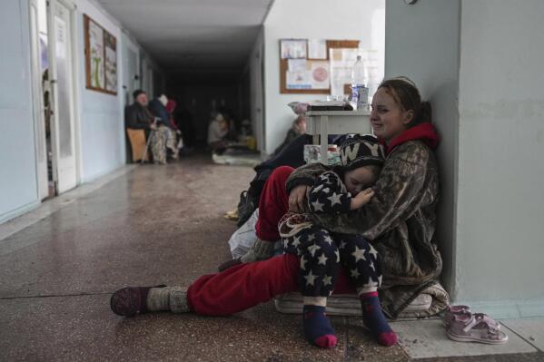 Anastasia Erashova cries as she hugs her child in a corridor of a hospital in Mariupol, Ukraine on Friday, March 11, 2022. Anastasia's other child was killed during shelling in Mariupol. (AP Photo/Evgeniy Maloletka)