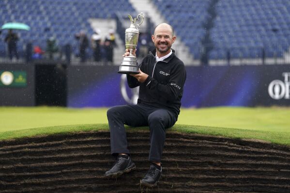 United States' Brian Harman poses for the media as he holds the Claret Jug trophy for winning the British Open Golf Championships at the Royal Liverpool Golf Club in Hoylake, England, Sunday, July 23, 2023. (David Davies/PA via AP)