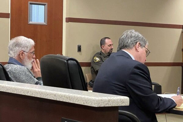 James Donald Holkeboer, left, and defense attorney Charles E. Chamberlain Jr. listen to proceedings during a preliminary hearing, Monday, Nov. 28, 2022, in Grand Rapids, Mich. An appeals court dismissed charges Thursday, APul 19, 2024, against Holkeboer, a Michigan election worker who put a USB flash drive into an electronic poll book and downloaded the names of voters at the close of a primary election in 2022. The court says Holkeboer’s conduct was improper but not a crime. (Bradley Massman/The Grand Rapids Press via AP)