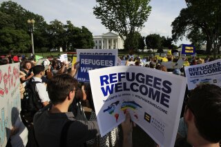 FILE - In this June 20, 2017 file photo, Refugees and community activists gather in front of the White House in Washington. The Trump administration wants to cap the number of refugees admitted into the United States to the lowest number since the resettlement program was created in 1980. A State Department proposal released Thursday would put a cap on the number of refugees at 18,000 for the fiscal year that starts Oct. 1.  (AP Photo/Manuel Balce Ceneta)