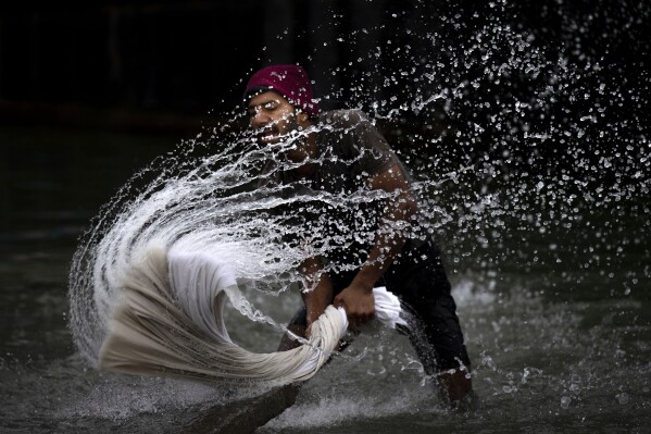 A washerman washes clothes on the banks of the river Brahmaputra on World Water Day in Guwahati, India, Wednesday, March 22, 2023. (AP Photo/Anupam Nath)