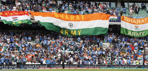 FILE- Indian national flags fly in the stands ahead of the ICC Champions Trophy match between India and South Africa in London, Sunday, June 11, 2017. Prime Minister Narendra Modi's government has replaced India with the Sanskrit word 'Bharat' in dinner invitations sent for the Group of 20 summit, in a move that echoes his Hindu nationalist party's efforts to scrub away what it sees as colonial-era names. Politics over India versus Bharat has gained ground since the opposition parties in July announced a new alliance — called INDIA. (AP Photo/Kirsty Wigglesworth, File)