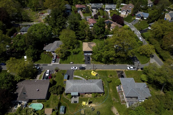 Groundwater empties into a dumpster while workers drill a hole for a geothermal heat pump system at a home in White Plains, N.Y., Monday, May 8, 2023. (AP Photo/Julia Nikhinson)