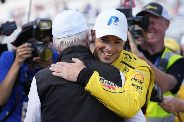 Scott McLaughlin, front right, of New Zealand, celebrates with Roger Penske, front left, after winning the pole for the Indianapolis 500 auto race at Indianapolis Motor Speedway, Sunday, May 19, 2024, in Indianapolis. (AP Photo/Darron Cummings)