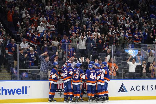 New York Islanders fans cheer after defenseman Noah Dobson scored the game-winning goal during overtime of an NHL hockey game against the Calgary Flames, Monday, Nov. 7, 2022, in Elmont, N.Y. The Islanders won 4-3 in overtime. (AP Photo/Julia Nikhinson)