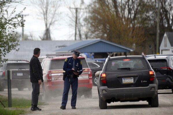 A law enforcement official monitors the perimeter of the Swan Creek Boat Club after a driver crashed a vehicle through a building where a children's birthday party was taking place, Saturday, April 20, 2024, in Berlin Township, Mich. (Kathleen Kildee/Detroit News via AP)