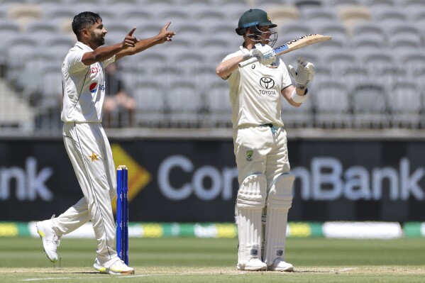 Khurram Shahzad, left, of Pakistan celebrates after taking the wicket of Australia's Steve Smith, right, on the fourth day of the first cricket test between Australia and Pakistan in Perth, Australia, Sunday, Dec. 17, 2023. (Richard Wainwright/AAP Image via AP)