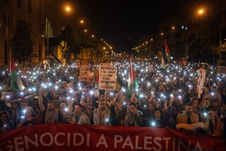 FILE - Demonstrators use the flashlights on their mobile phones as they protest against Israeli attacks on Gaza, in Barcelona, Spain on Nov. 11, 2023. (AP Photo/Emilio Morenatti, File)