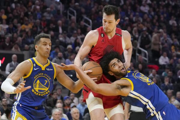 Portland Trail Blazers forward Drew Eubanks, middle, reaches for the ball between Golden State Warriors forward Patrick Baldwin Jr. (7) and forward Anthony Lamb during the first half of an NBA basketball game in San Francisco, Tuesday, Feb. 28, 2023. (AP Photo/Jeff Chiu)