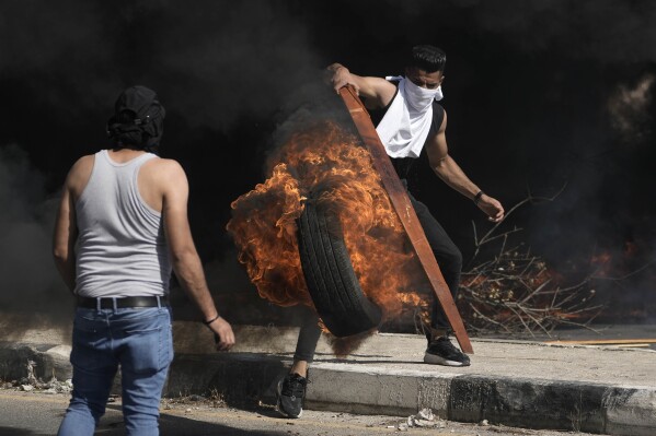 Palestinian demonstrators clash with Israeli forces following a demonstration in support of the Gaza Strip, in the West Bank city of Nablus, Friday, Oct. 13, 2023. (AP Photo/Majdi Mohammed)