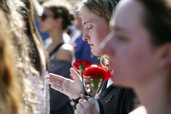 People gather to mourn the loss of Laken Riley during a vigil for the Augusta University College of Nursing student at the Tate Plaza on the University of Georgia campus in Athens, Ga., Monday, Feb. 26, 2024. Riley, a nursing student at Augusta University's Athens campus, was found dead Thursday, Feb. 22, after a roommate reported she didn't return from a morning run in a wooded area of the UGA campus near its intramural fields. Students also gathered to pay tribute to a UGA student who committed suicide last week. (Joshua L. Jones/Athens Banner-Herald via AP)