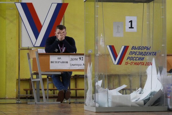 A member of an election commission waits for voters at a polling station during a presidential election in St. Petersburg, Russia, Friday, March 15, 2024. Voters in Russia headed to the polls for a presidential election that was all but certain to extend President Vladimir Putin's rule after he clamped down on dissent. (AP Photo/Dmitri Lovetsky)