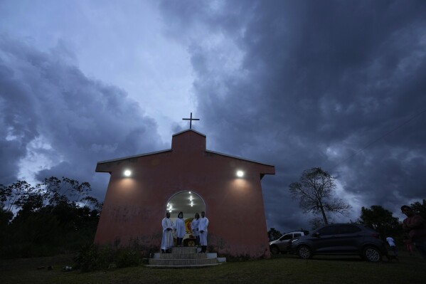 A Catholic church receives worshippers for Mass in the rural area of the Rio Branco, Acre state, Brazil, Monday, May 22, 2023. (AP Photo/Eraldo Peres)