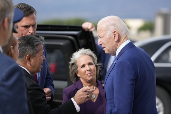 President Joe Biden greets Gov. Lujan Grisham, center, along with Sen. Ben Ray Lujan, D-N.M., and Sen. Martin Heinrich, D-N.M., back left, upon arrival at Kirtland Air Force Base, Tuesday, Aug. 8, 2023, in Albuquerque, N.M. (AP Photo/Alex Brandon)