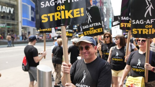 FILE - Actor Jason Kravits carries a sign on a picket line outside Paramount in Times Square in New York on July 17, 2023. (Photo by Charles Sykes/Invision/AP)