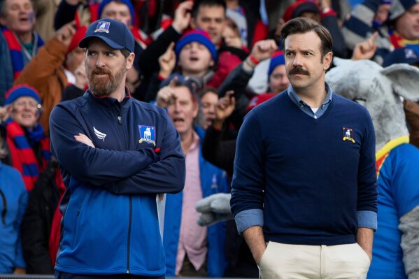 This image released by Apple TV Plus shows Brendan Hunt, left, and Jason Sudeikis in "Ted Lasso," premiering globally on Friday, August 14. (Apple TV Plus via AP)