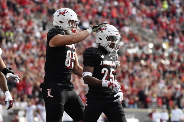 Louisville tight end Nate Kurisky (85) pats running back Jawhar Jordan (25) on the helmet after scoring a touchdown during the first half of an NCAA college football game against Virginia Tech in Louisville, Ky., Saturday, Nov. 4, 2023. (AP Photo/Timothy D. Easley)