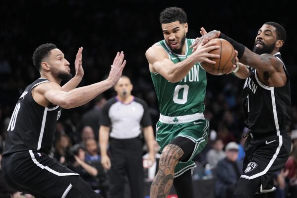 Brooklyn Nets guard Ben Simmons (10) and guard Kyrie Irving guard Boston Celtics forward Jayson Tatum (0) during the first half of an NBA basketball game Thursday, Jan. 12, 2023, in New York. (AP Photo/Mary Altaffer)