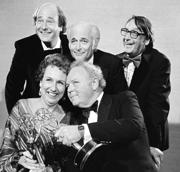 FILE - Actors Jean Stapleton, seated, left, and Carroll O'Connor, seated, right, from "All in the Family" hold their Emmys for outstanding lead actress and actor in a comedy series, as they pose with co-star Rob Reiner, who won for supporting actor in a comedy series, standing left, producer Norman Lear, and executive producer Mort Lachman, standing right, in Los Angeles on Sept. 18, 1978. (AP Photo, File)