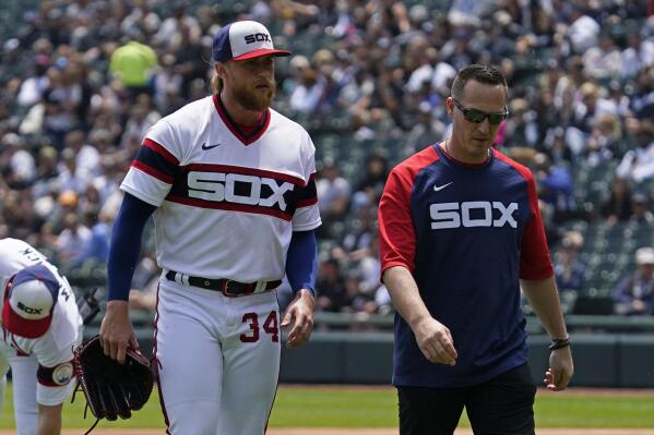 Chicago White Sox starting pitcher Michael Kopech, front left, walks to the dugout with a team trainer after being injured during the first inning of a baseball game against the Texas Rangers in Chicago, Sunday, June 12, 2022. (AP Photo/Nam Y. Huh)