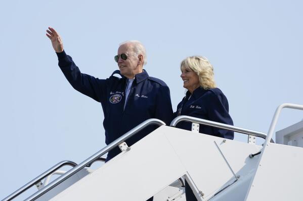 President Joe Biden waves as he stands at the top of the steps of Air Force One before boarding with first lady Jill Biden at Andrews Air Force Base, Md., Saturday, Sept. 17, 2022, as they head to London to attend the funeral for Queen Elizabeth II. To commemorate the U.S. Air Force's 75th Anniversary as a service the Bidens are wearing Air Force One jackets. (AP Photo/Susan Walsh)