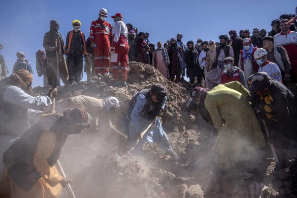 Iranian rescue team and Afghan men search for victims after an earthquake in Zenda Jan district in Herat province, of western Afghanistan, Monday, Oct. 9, 2023. Saturday's deadly earthquake killed and injured thousands when it leveled an untold number of homes in Herat province. (AP Photo/Ebrahim Noroozi)