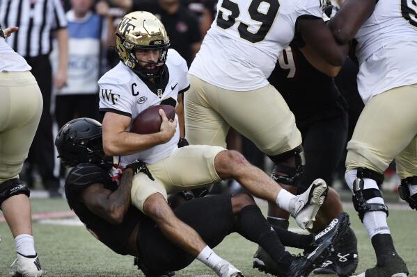 Wake Forest quarterback Sam Hartman (10) is sacked by Louisville defensive back Kei'Trel Clark (13) during the first half of an NCAA college football game in Louisville, Ky., Saturday, Oct. 29, 2022. (AP Photo/Timothy D. Easley)