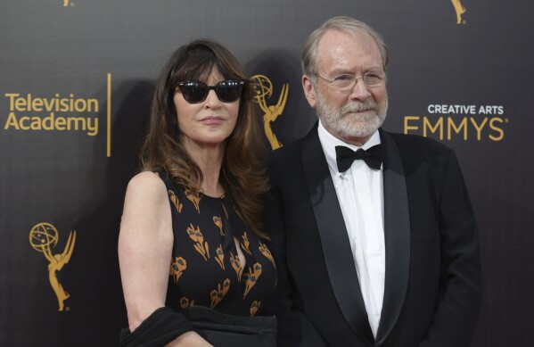 FILE -Wendy Haas, left, and Martin Mull arrive at night one of the Creative Arts Emmy Awards at the Microsoft Theater on Saturday, Sept. 10, 2016, in Los Angeles. Martin Mull, whose droll, esoteric comedy and acting made him a hip sensation in the 1970s and later a beloved guest star on sitcoms including “Roseanne” and “Arrested Development,” has died, his daughter said Friday, June 28, 2024. (Photo by Richard Shotwell/Invision/AP, File)