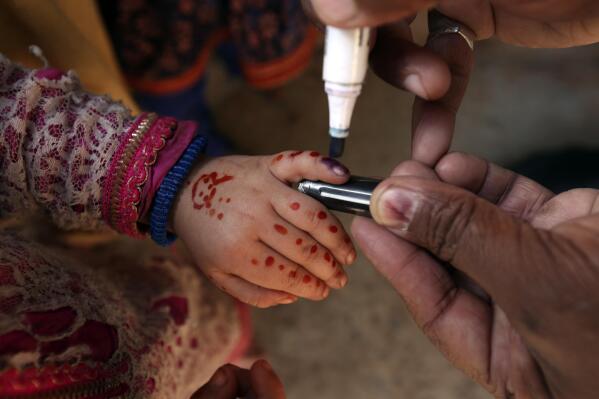 A health worker marks the finger of a child after receiving the polio vaccine in Lahore, Pakistan, Monday, Feb. 28, 2022. (AP Photo/K.M. Chaudary)
