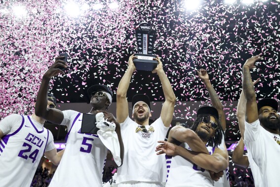 FILE - Grand Canyon's Lok Wur, Gabe McGlothan, and Collin Moore celebrate after defeating Texas-Arlington in an NCAA college basketball game for the championship of the Western Athletic Conference tournament Saturday, March 16, 2024, in Las Vegas. Grand Canyon University and Seattle University will join the West Coast Conference beginning with the 2025-26 season, giving the league best known nationally for its basketball programs 11 full members for the first time in its history. The conference announced the additions Friday, May 10, 2024, with the two schools set to leave their affiliations with the Western Athletic Conference after the next school year.(AP Photo/Ian Maule, File)