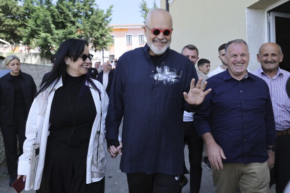 Albania's ruling Socialist party leader Edi Rama, center, and his wife Linda, left, leave a voting station during a general election where Rama is seeking a fourth term as Albania's prime minister in Tirana, Albania Sunday, May 11, 2025. (AP Photo/Vlasov Sulaj)