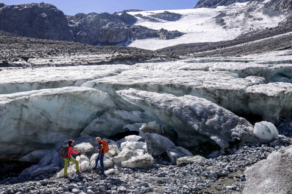 Glaciologist Andrea Fischer, right, from the Austrian Academy of Sciences talks to colleague Violeta Lauria at the Jamtalferner Glacier near Galtuer, Austria, Wednesday, Sept. 6, 2023. (AP Photo/Matthias Schrader)