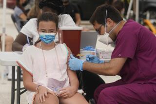 Francesca Anacleto, de 12 años, recibe su primera dosis de la vacuna de Pfizer contra el COVID-19 aplicada por el enfermero Jorge Tase en Miami Beach, Florida, el 4 de agosto de 2021. (AP Foto/Marta Lavandier)