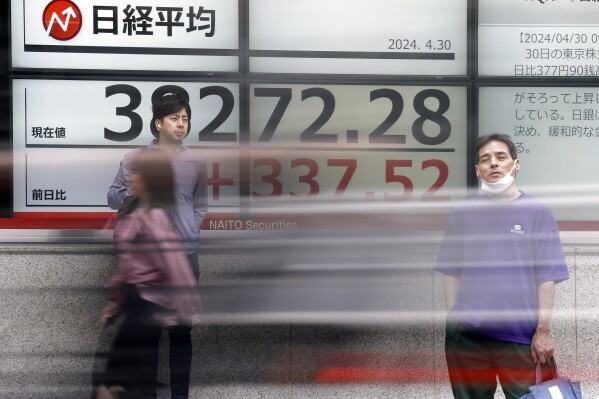 People stand in front of an electronic stock board showing Japan's Nikkei 225 index at a securities firm Tuesday, April 30, 2024, in Tokyo. Asian shares mostly rose Tuesday, as investors kept their eyes on potentially market-moving reports expected later this week.(AP Photo/Eugene Hoshiko)