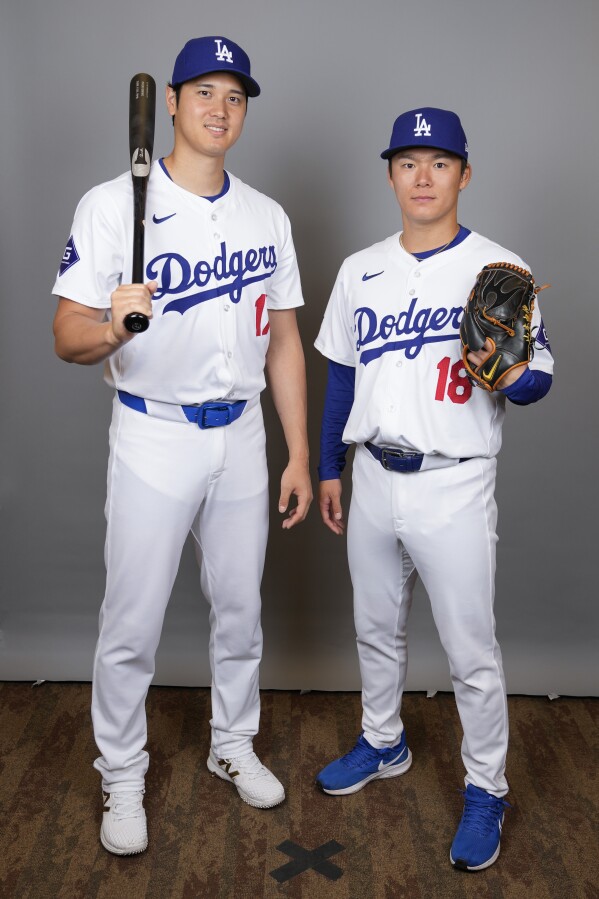 Los Angeles Dodgers designated hitter Shohei Ohtani, left, and starting pitcher Yoshinobu Yamamoto pose for a photo during a spring training baseball photo day on Wednesday, Feb. 21, 2024, in Phoenix. (AP Photo/Ashley Landis)