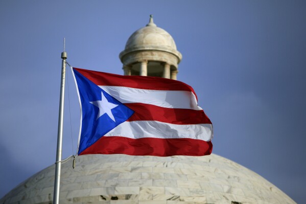 FILE - The Puerto Rican flag flies in front of Puerto Rico's Capitol as in San Juan, Puerto Rico, July 29, 2015. Puerto Rico’s Republican Party held a district assembly Sunday, April 21, 2024, and awarded former President Donald Trump all 23 of their national delegates. About 77% of the 1,340 members that make up the U.S. territory’s Republican Party participated. (AP Photo/Ricardo Arduengo, File)