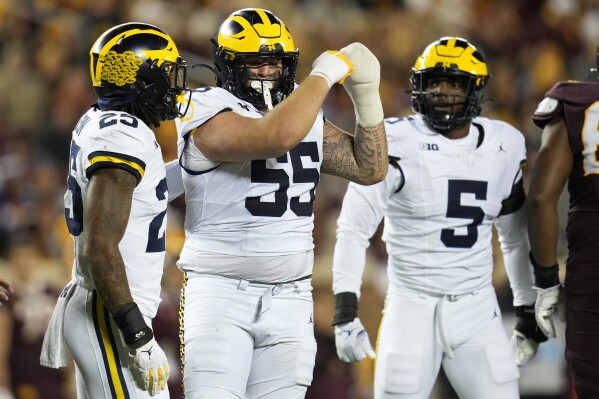 Michigan defensive lineman Mason Graham (55) celebrates after making a tackle during the second half of an NCAA college football game against Minnesota, Saturday, Oct. 7, 2023, in Minneapolis. (AP Photo/Abbie Parr)